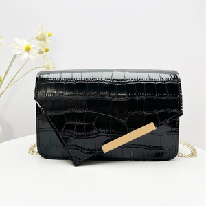 Black crocodile pattern flap crossbody bag with gold chain and metal bar detail