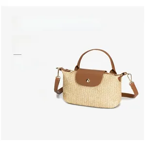 Detail of woven straw texture and premium brown leather strap on summer crossbody bag