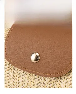 Macro shot of straw texture bag with brown leather flap and golden round metal lock