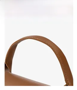 Detail view of reinforced double stitching on the brown leather handbag handle strap