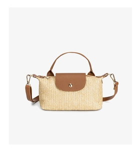 Detail of beige straw bag with herringbone texture and brown leather magnetic closure