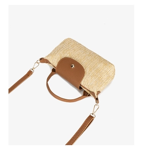Detail of chevron straw mini bag with brown leather flap and golden snap button