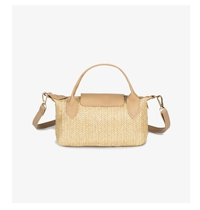 Detail of straw woven texture and brown leather flap on a mini crossbody handbag