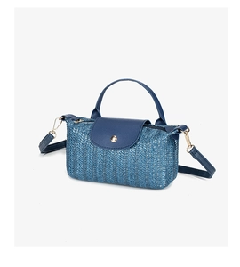 Detail of blue straw woven texture with leather flap and golden snap closure on crossbody bag