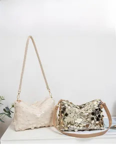 Détail de sacs à bandoulière à paillettes en beige et or avec bandoulières en cuir et zips