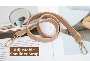 Détail d'une bandoulière réglable en cuir kaki avec des mousquetons en métal doré