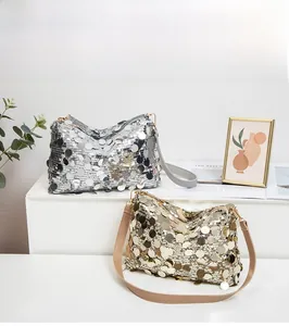 Détails de sacs à bandoulière à paillettes dorées et argentées sur un socle d'exposition
