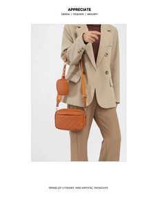 Detail of orange quilted crossbody camera bag with adjustable strap and round coin purse