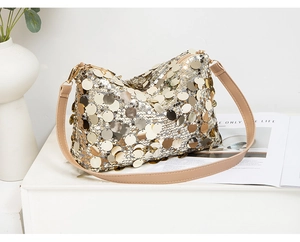 Gros plan des paillettes dorées du sac à bandoulière avec une texture métallique
