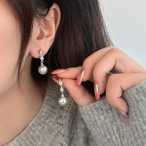 Boucles d'oreilles perles et zircons marquise portées par un mannequin sur pull gris