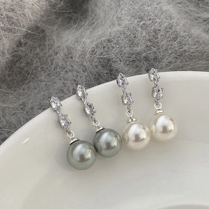 Boucles d'oreilles élégantes avec perles grises et blanches et zircon sur plat en céramique