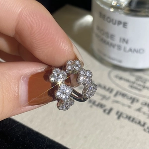 Macro shot of silver flower hoop earrings featuring micro-pave zircons and floral motifs