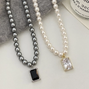 Detailed macro view of pearl necklaces with emerald-cut stones and zircon frames
