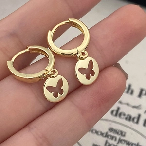 Gold minimalist hoop earrings with hollow butterfly round pendant held in hand
