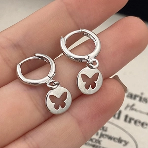 Minimalist silver hoop earrings with hollow butterfly round pendant on a jewelry card