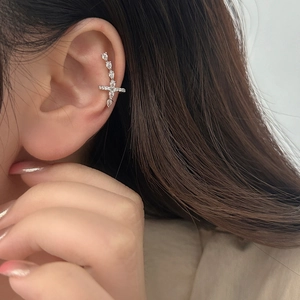 Elegant silver cross ear cuff with sparkling pavé zircons worn on the cartilage