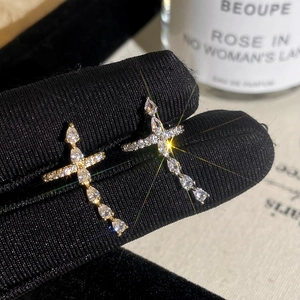 Sparkling cubic zirconia cross earrings in gold and silver plating on velvet display