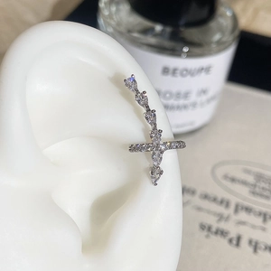 Close-up of sparkling silver cross ear crawler earrings with cubic zirconia on a model