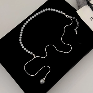 Detail view of adjustable dark gray pearl and silver snake chain necklace on black velvet
