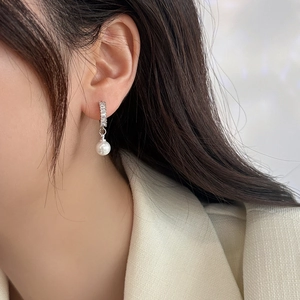 Elegant silver pendant earrings with rectangular zircon and white pearl on a female model