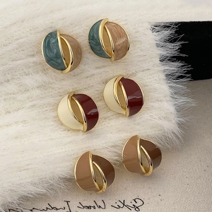 Three pairs of vintage enamel geometric hoop earrings with gold trim on soft fabric