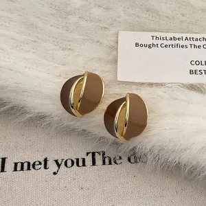 Close-up of retro abstract twisted earrings with brown enamel and gold metal frame
