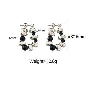 Detail view of C-shaped silver and black earrings with size labels and weight info