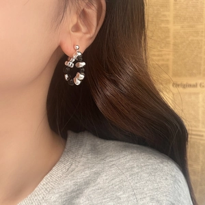 Detail of silver irregular metal beads and black round beads on a stylish drop earring