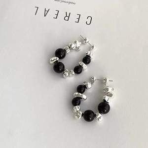 Detail of beaded earrings featuring black onyx beads and irregular silver crushed metal