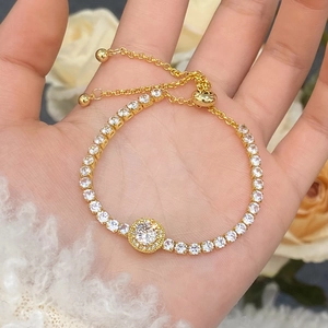 Detail of adjustable gold tennis bracelet featuring micro-pave cubic zirconia and bolo clasp