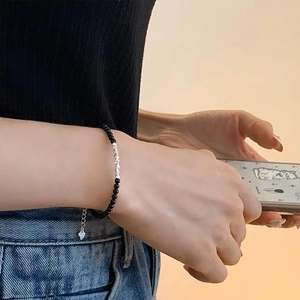 Minimalist bracelet with black beads, silver metal accents and a heart charm pendant