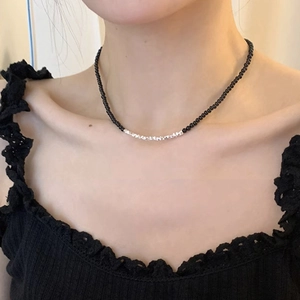 Detail of beaded necklace with silver zircon accents on a female model collarbone