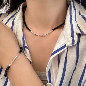Detailed set of black beads and silver cubic metal beads on necklace and bracelet
