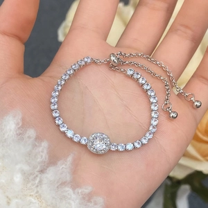 Detail of adjustable silver-toned tennis bracelet with halo zircon and slider clasp
