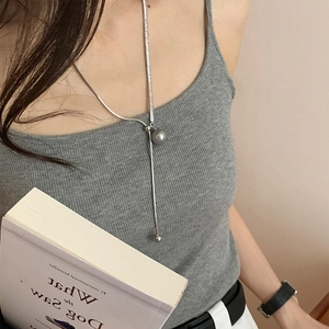 Close-up of a silver Y-shaped long necklace featuring a grey pearl and metallic bead
