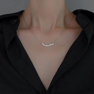 Collier torsadé argenté élégant avec pierres en zircon sur un mannequin avec chemise noire