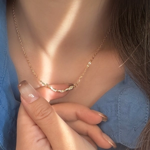 Gros plan d'un collier en maille torsadée dorée avec pendentif zircon sur mannequin