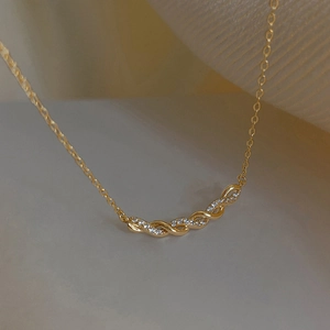 Gros plan détaillé du pendentif croissant torsadé doré serti de zircons scintillants