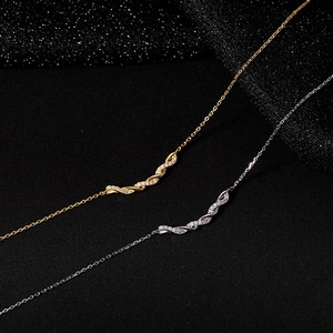 Détail de colliers avec pendentifs torsadés sertis de zircons en finitions or et argent