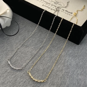 Détails de colliers torsadés en or et argent sertis de zircones sur fond élégant