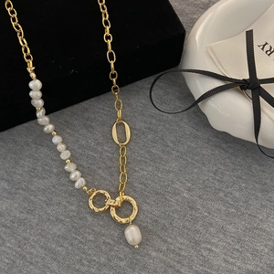 Detail of freshwater pearl necklace with hammered gold metal rings and textured chain