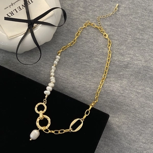 Detail of gold chain necklace featuring baroque pearls and a secure lobster clasp closure