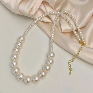 Détail du collier de perles dégradées avec une chaîne d'extension en métal doré élégante