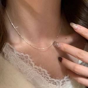 Minimalist silver chain necklace with metal square sequins shown on a female model