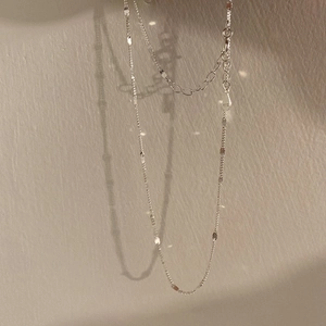 Detail of S925 sterling silver minimalist chain with square pendants and geometric shadows