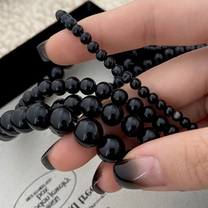 Detail showing polished black natural stone beads in various sizes for layering