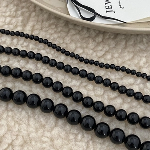Detail view of black natural stone beaded necklaces in four different bead diameter sizes