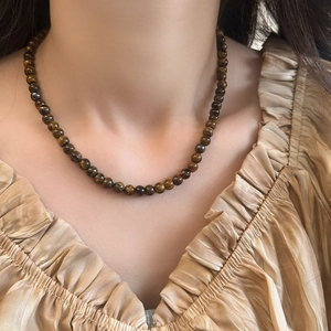 Détail d'un collier de perles en œil de tigre naturel avec un éclat soyeux doré