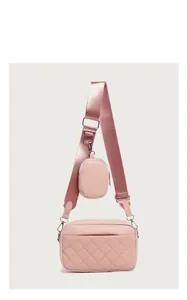 Detail of pink quilted camera bag with wide strap and matching round coin purse