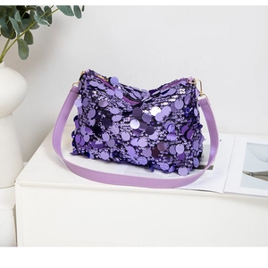 Détail du sac à main à paillettes violettes avec bandoulière en cuir sur socle moderne